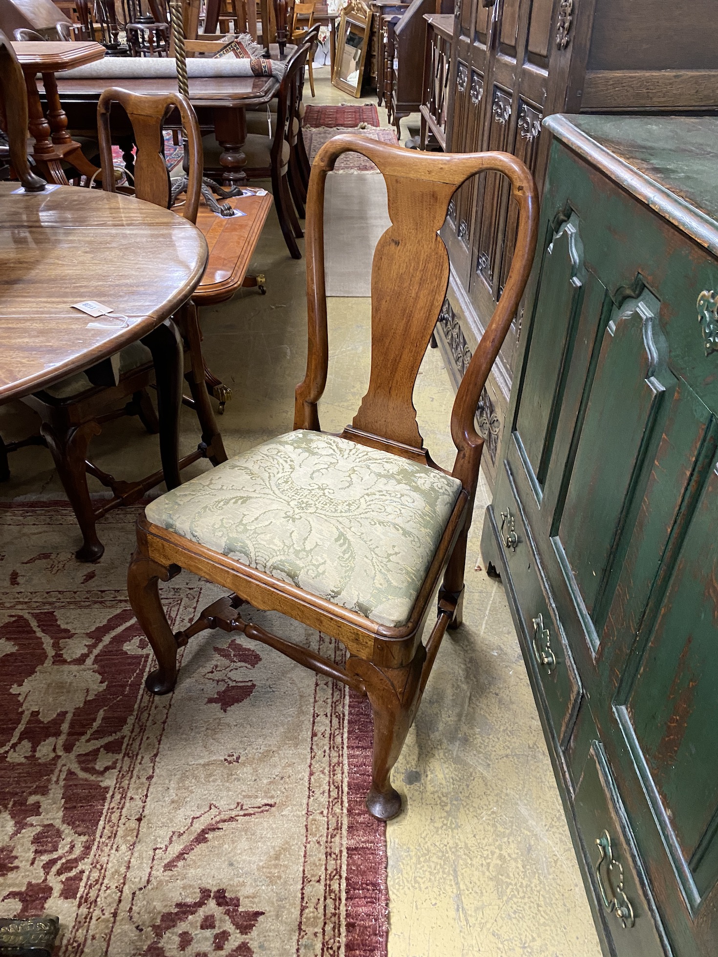 A set of four George I walnut dining chairs and two later matching elbow chairs with upholstered drop in seats on cabriole front legs.